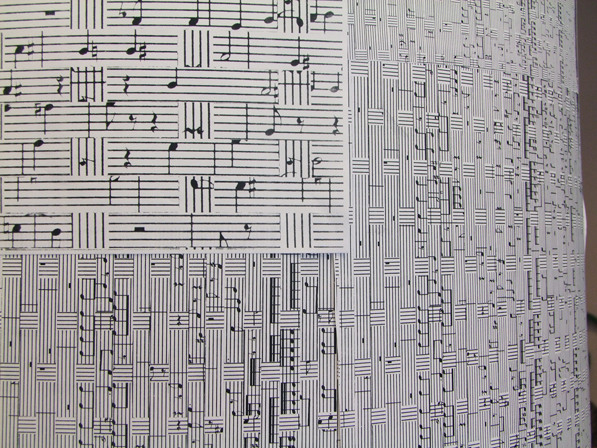 En vägg är täckt med notblad som är sammanvävda av sönderklippta symfonier.