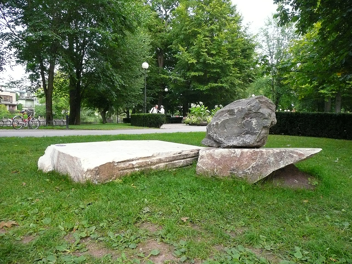 På en gräsmatta ligger tre stenblock.