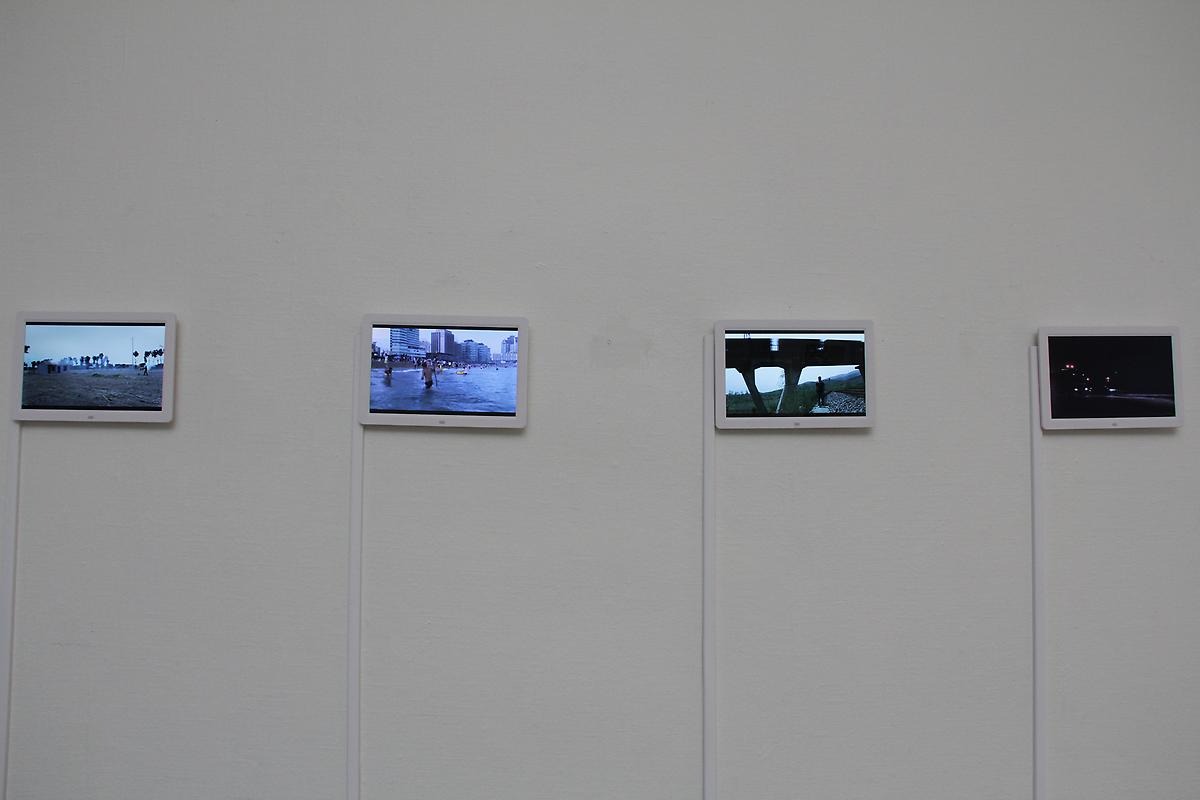 På en vitt vägg hänger fyra ipads som visar upp filmer från olika miljöer. 