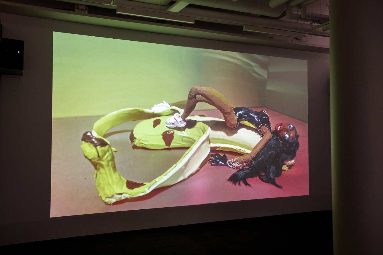 En videoanimation där en lerfigur ligger på en banan. 