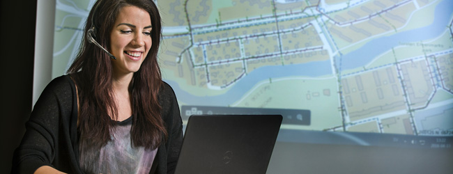 Bild på leende kvinna vid dator.